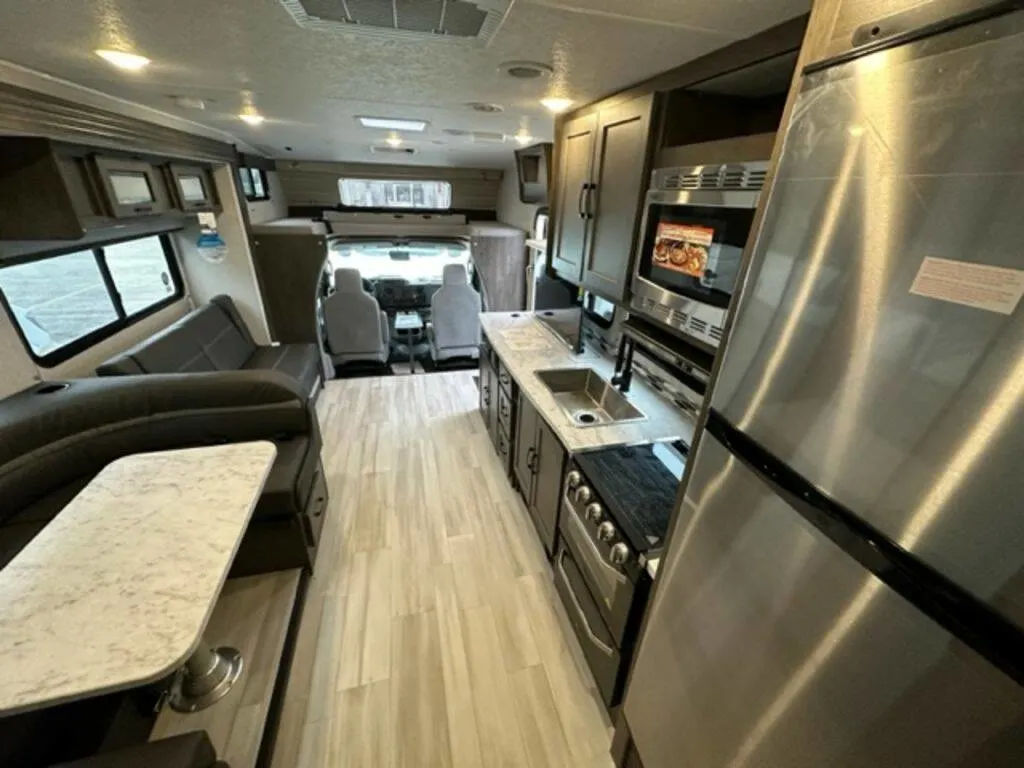 Interior view of the RV with a dinette, living space and a kitchen.