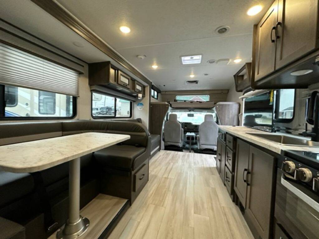 Interior view of the RV with a dinette, living space and a kitchen.