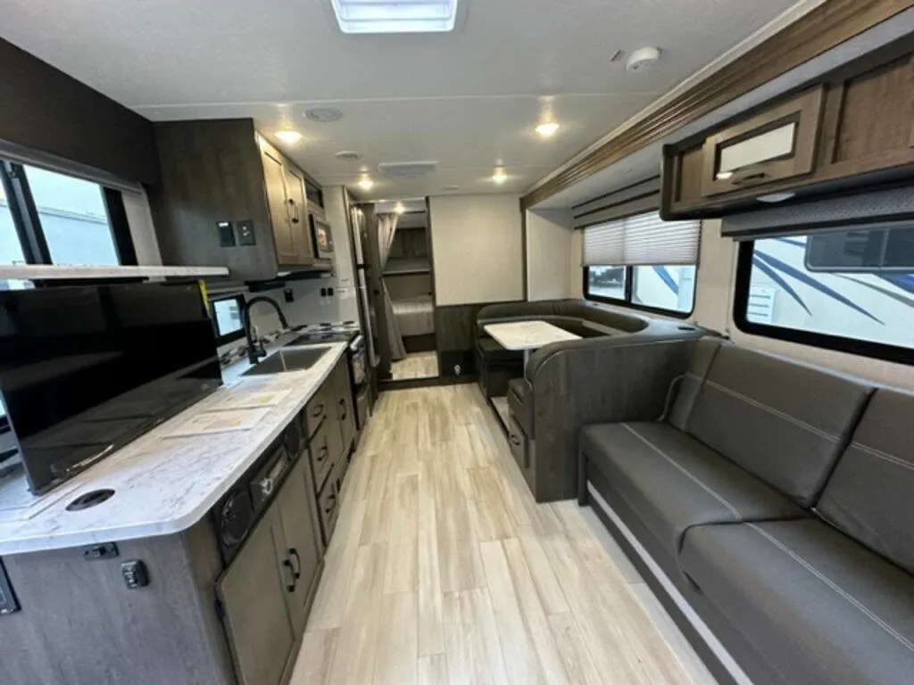 Interior view of the RV with a dinette, living space and a kitchen.