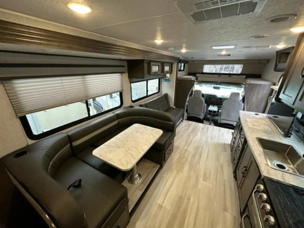 Interior view of the RV with a dinette, living space and a kitchen.