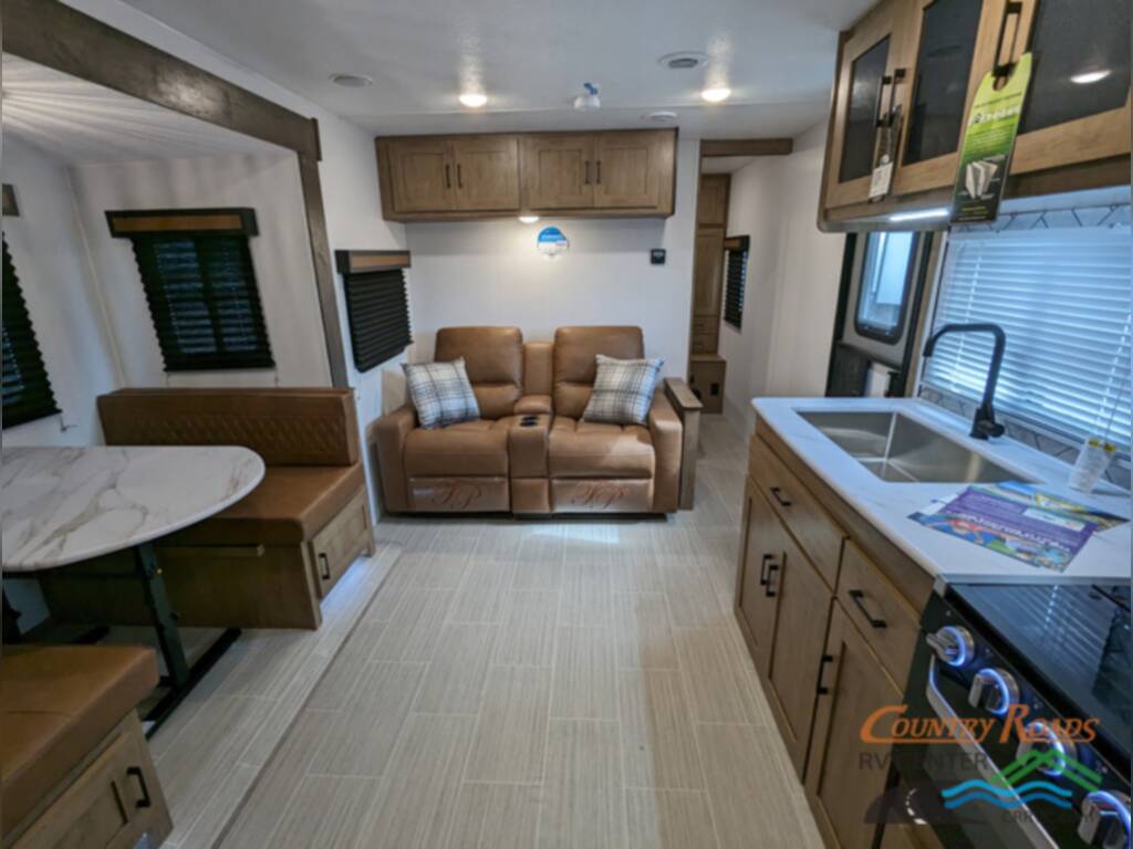 Interior view of the RV with a dinette, living area and a kitchen.