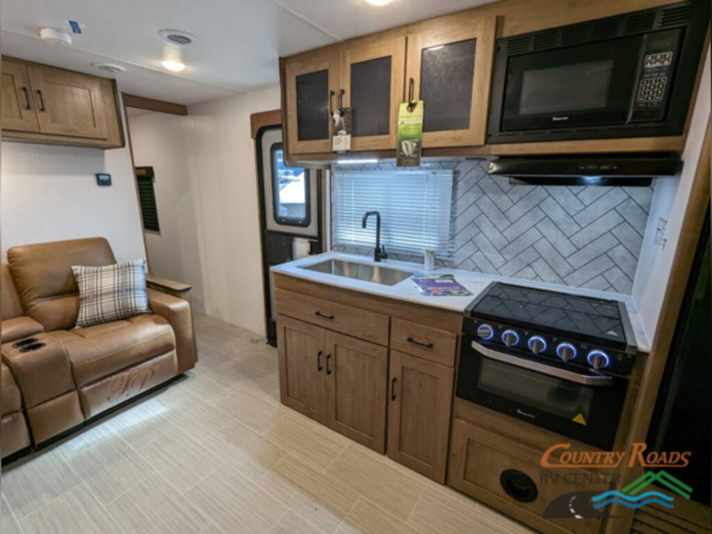 Kitchen with a gas burner, oven, sink and cabinets.