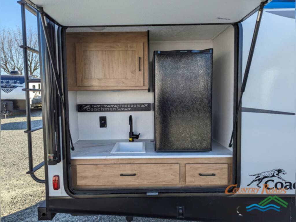 Full camp kitchen with a sink and a fridge.