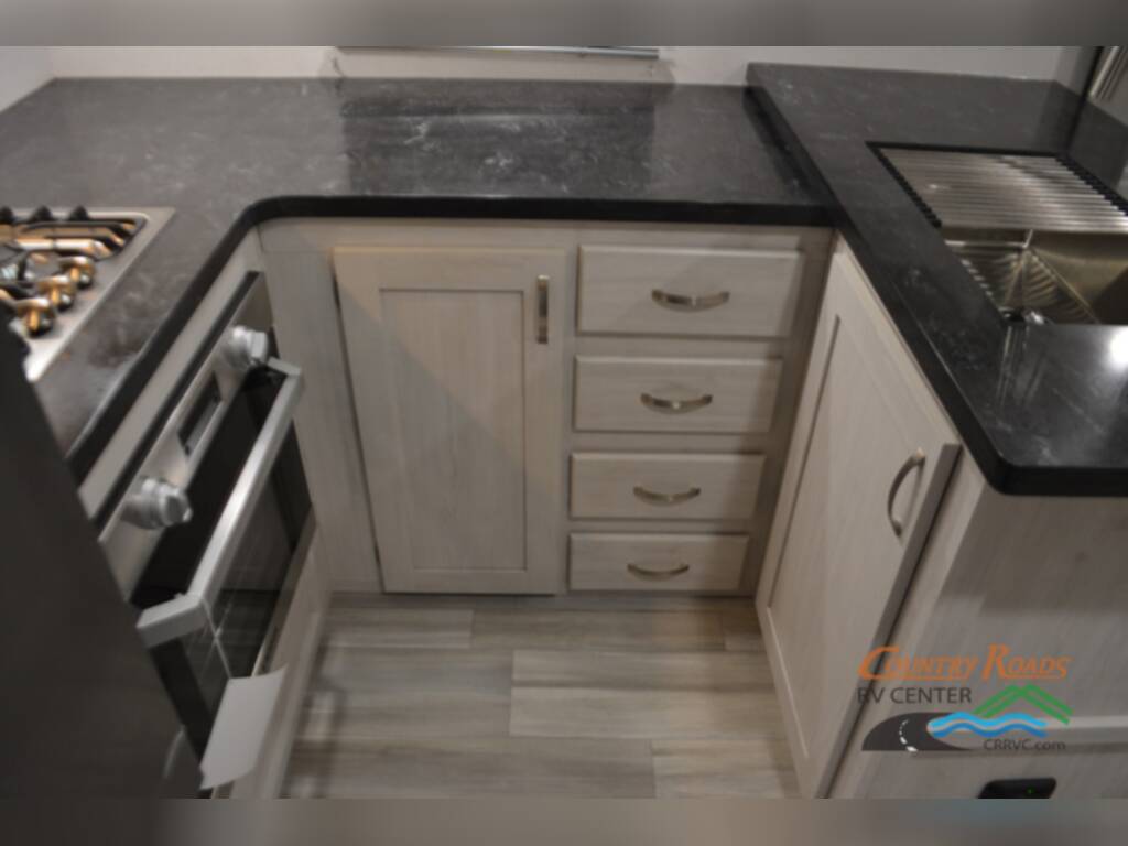 Kitchen with a gas burner, sink and cabinets.