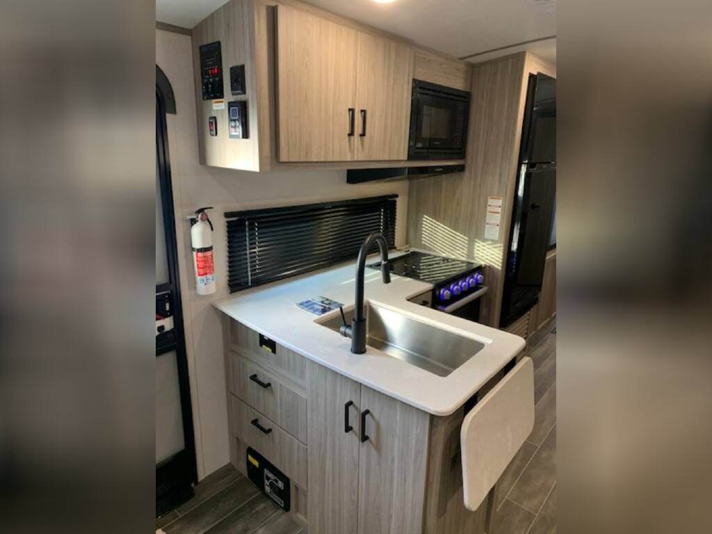 Kitchen with a gas burner, fridge, oven, sink and cabinets.