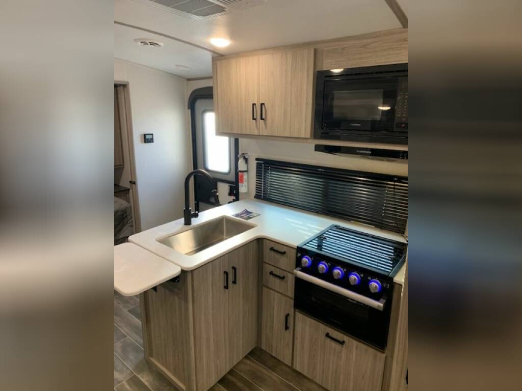 Kitchen with a gas burner, fridge, oven, sink and cabinets.