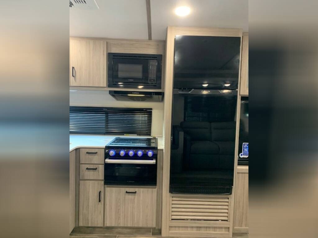 Kitchen with a gas burner, fridge, oven, and cabinets.