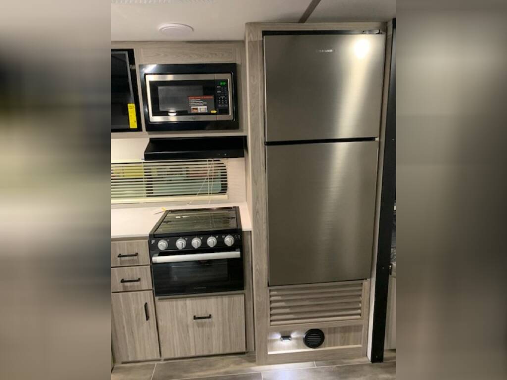 Kitchen with a gas burner, fridge, oven, and cabinets.