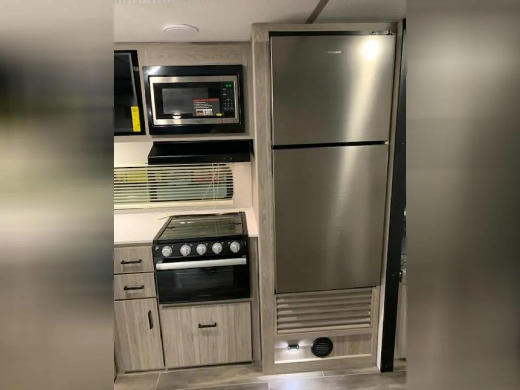 Kitchen with a gas burner, fridge, oven, and cabinets.