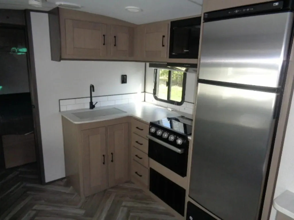 Kitchen with a gas burner, fridge, oven, sink and cabinets.