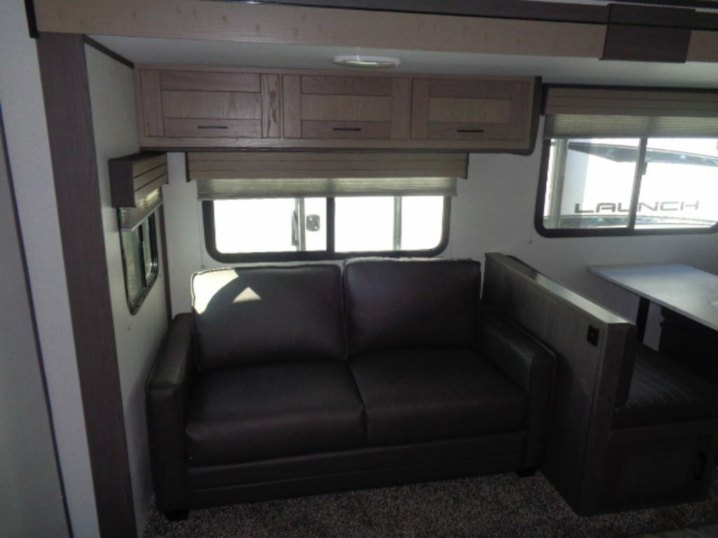 Living space with a sofa and overhead cabinets.