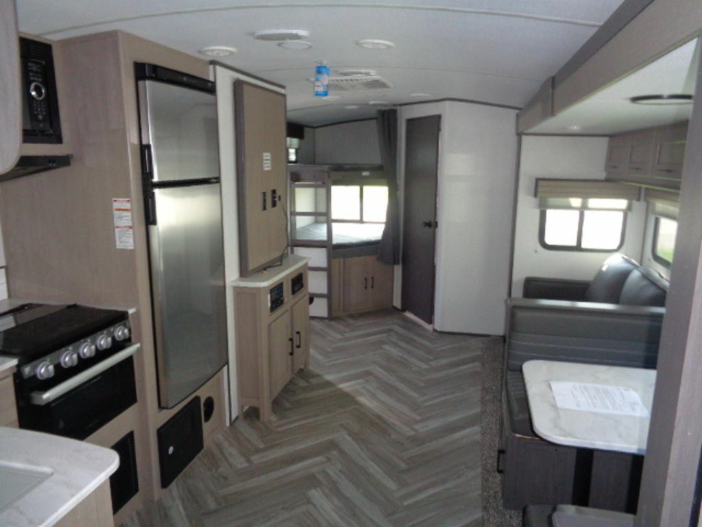 Interior view of the RV with a dinette, living space and a kitchen.