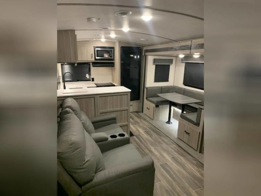 Interior view of the RV with a dinette, living area and a kitchen.