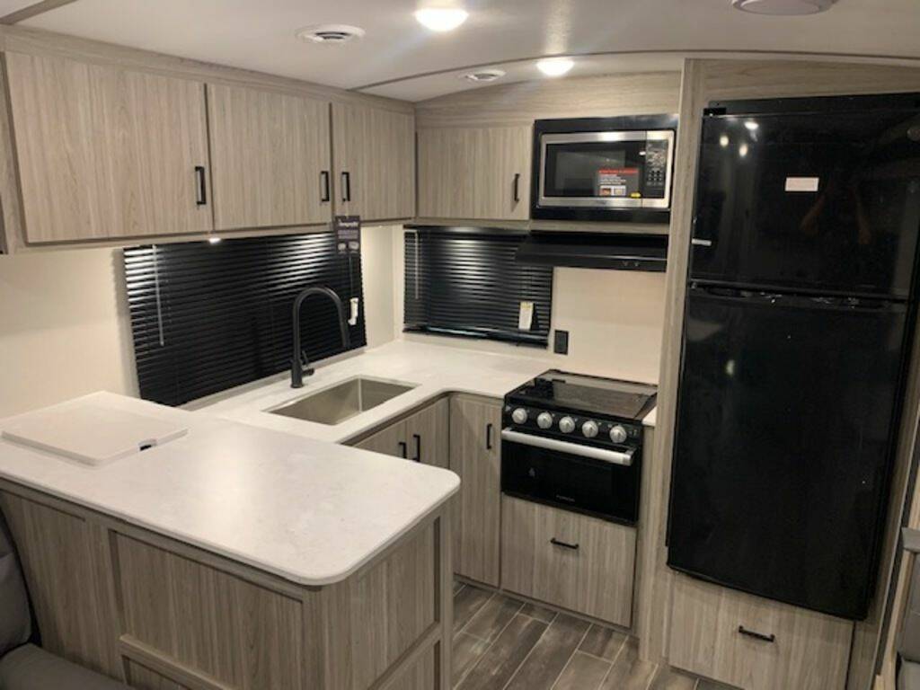 Kitchen with a gas burner, fridge, oven, sink and cabinets.