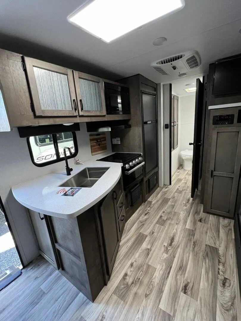 Kitchen with a gas burner, fridge, oven, sink and cabinets.