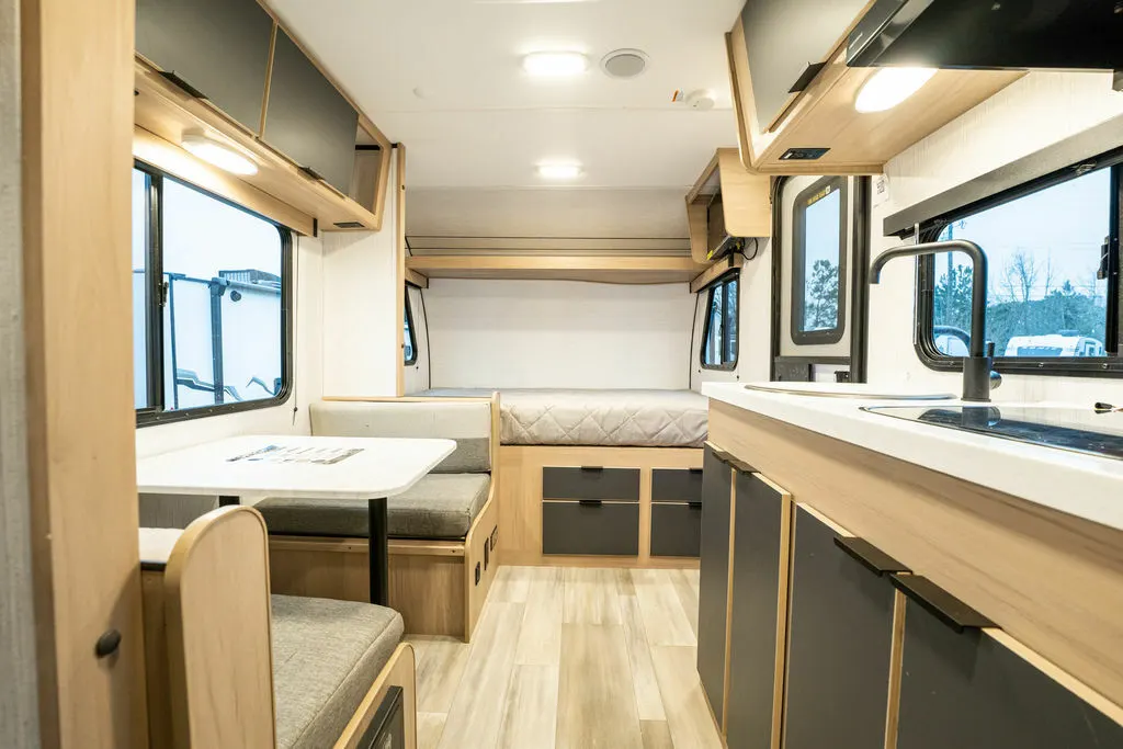 Interior view of the RV with a dinette, sleeping area and a kitchen.