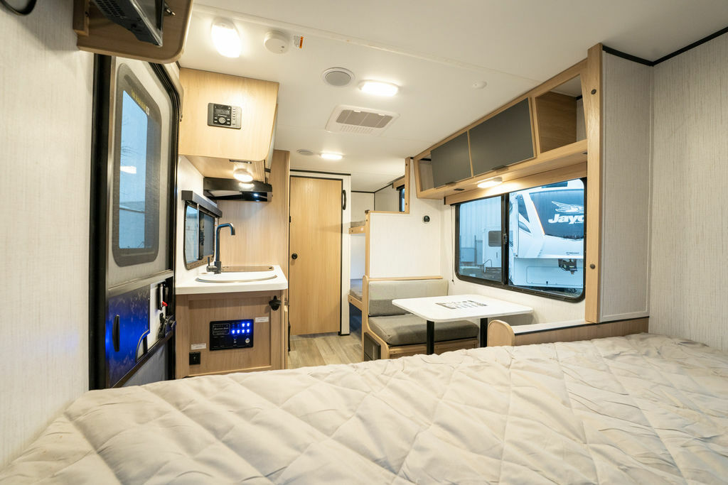 Interior view of the RV with a dinette, sleeping area and a kitchen.