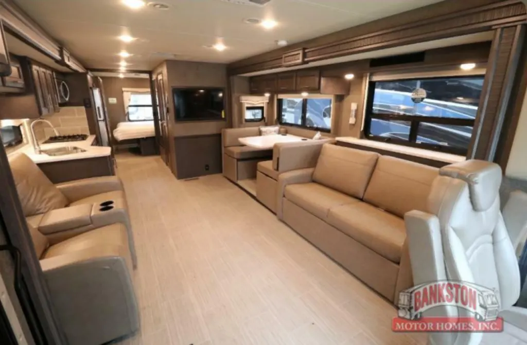 Interior view of the RV with a dinette, living space and a kitchen.