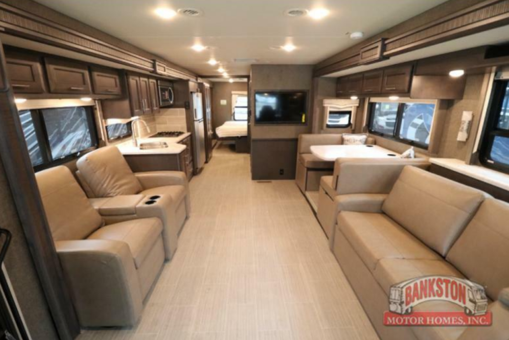 Interior view of the RV with a dinette, living space and a kitchen.