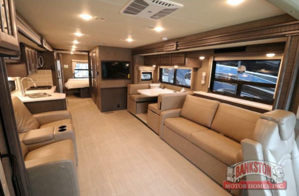 Interior view of the RV with a dinette, living space and a kitchen.