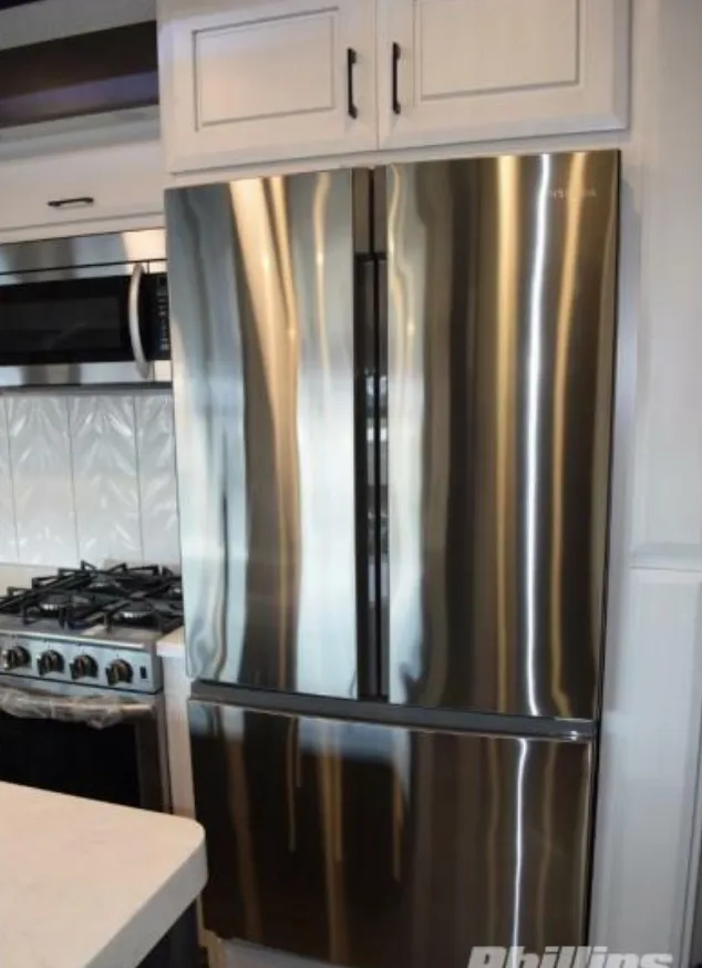 Kitchen with a gas burner, fridge, oven, and cabinets.