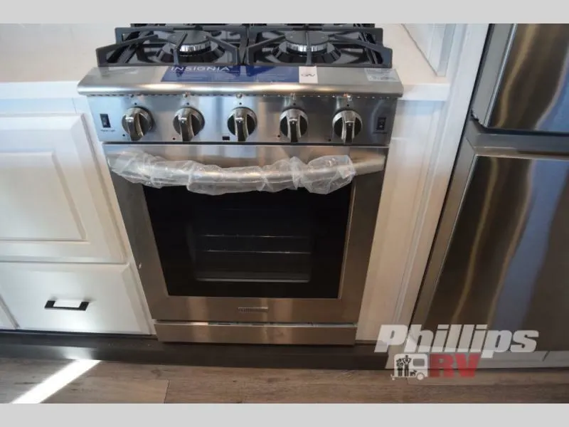 Kitchen with a gas burner, fridge and cabinets.