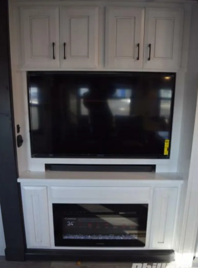 Entertainment center with a TV and a fireplace.