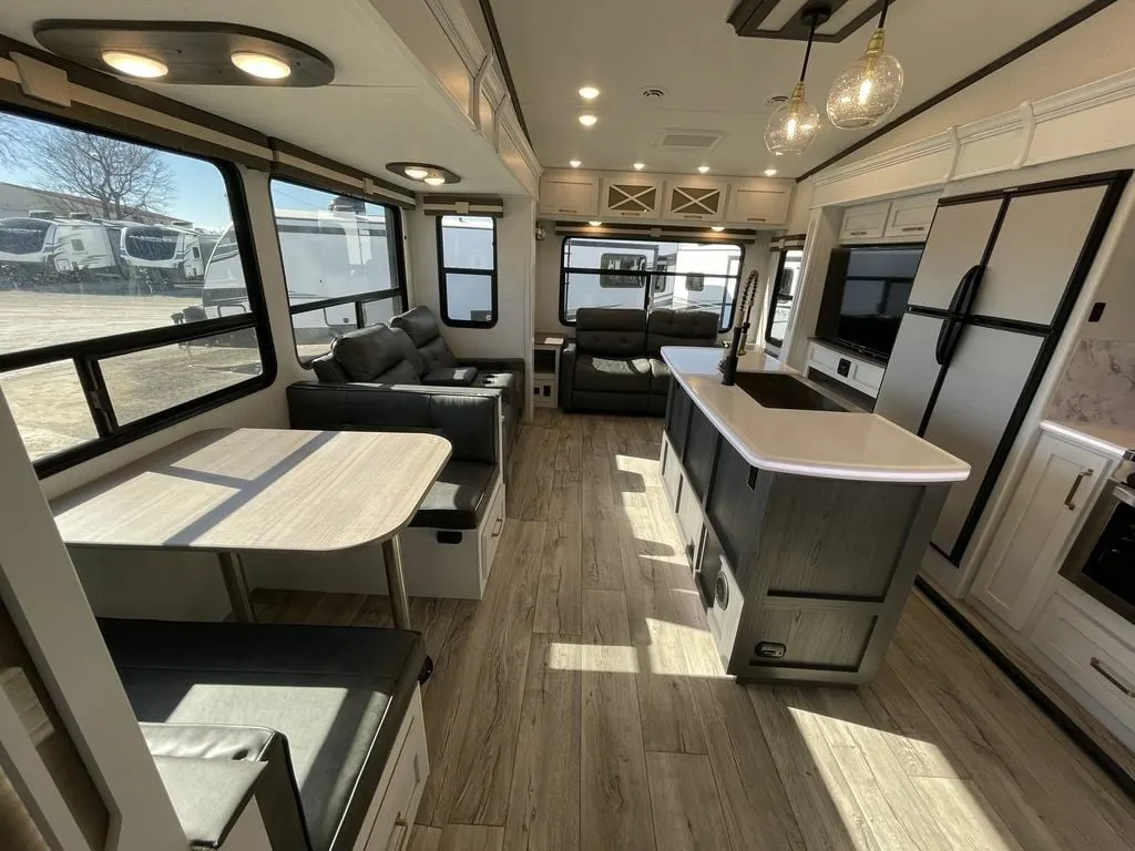 Interior view of the RV with a dinette, living space and a kitchen.