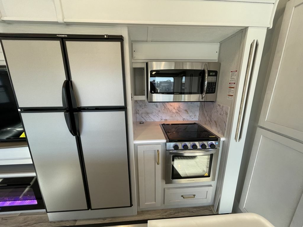 Kitchen with a gas burner, fridge, oven, and cabinets.