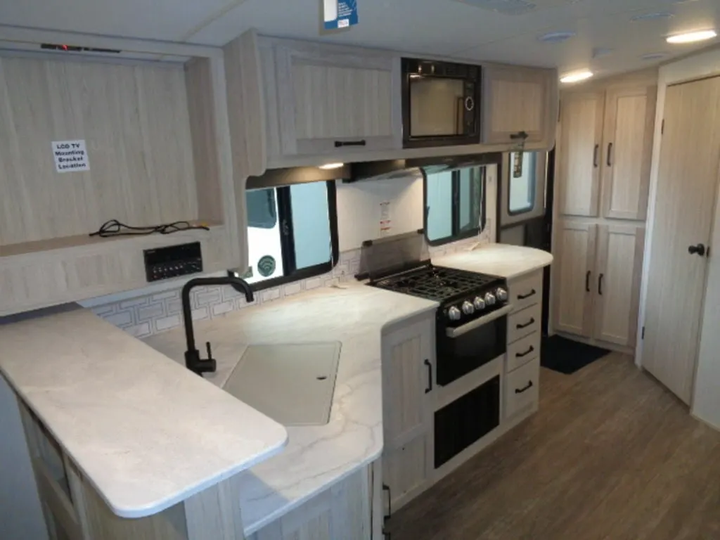 Kitchen with a gas burner, oven, sink and cabinets.