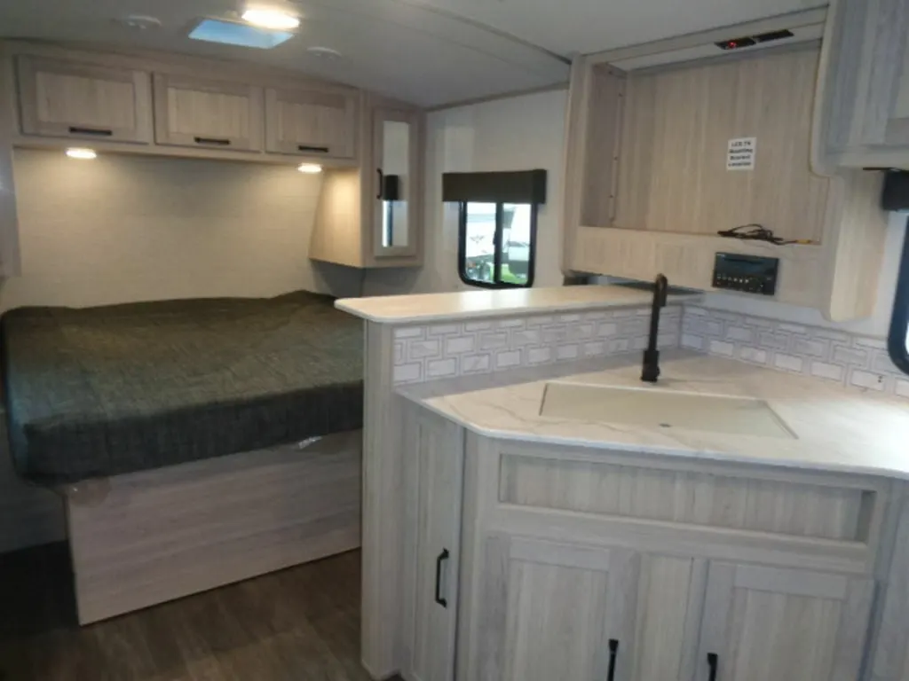 Bedroom with a king size bed and overhead cabinets.