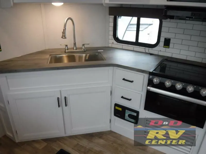 Kitchen with a gas burner, sink and cabinets.