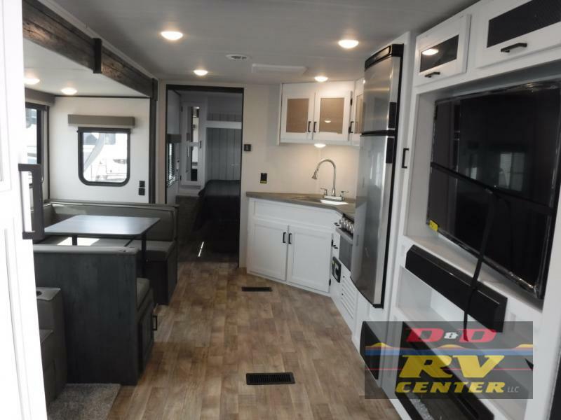 Interior view of the RV with a dinette, living space and a kitchen.