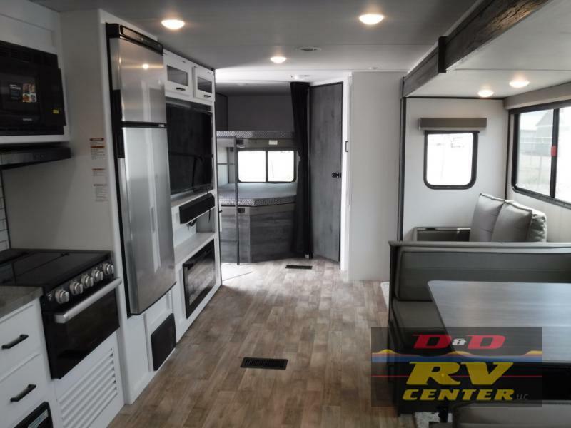 Interior view of the RV with a dinette, living space and a kitchen.