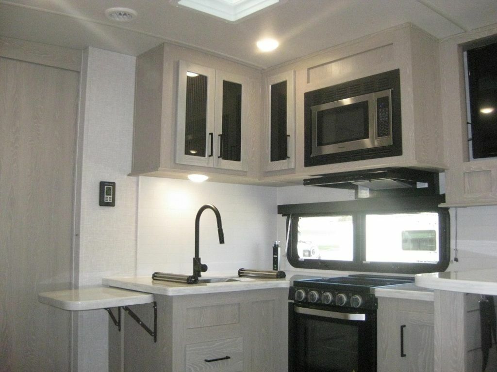 Kitchen with a gas burner, oven, sink and cabinets.