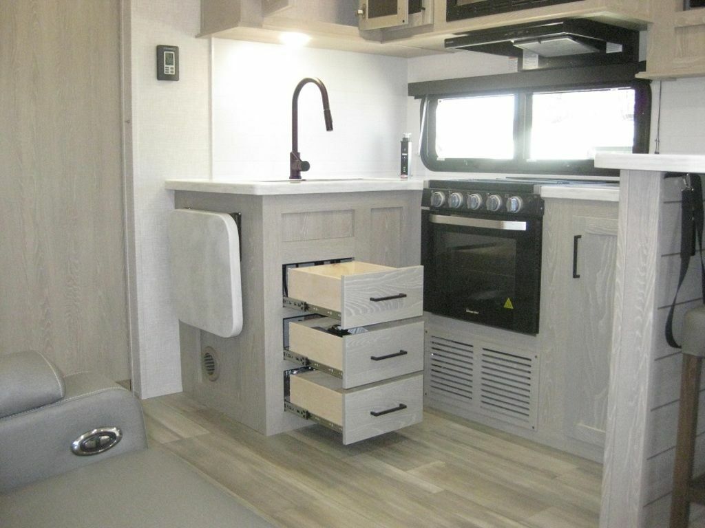 Kitchen with a gas burner, oven, sink, drawers and cabinets.