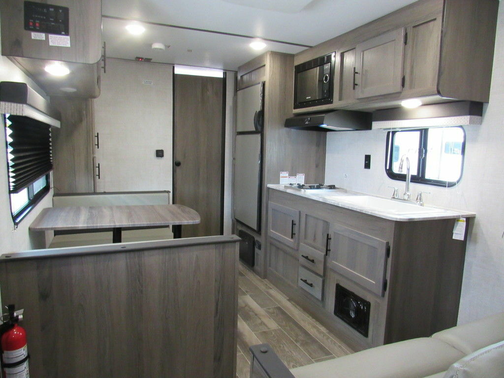 Interior view of the RV with a dinette, living space and a kitchen.