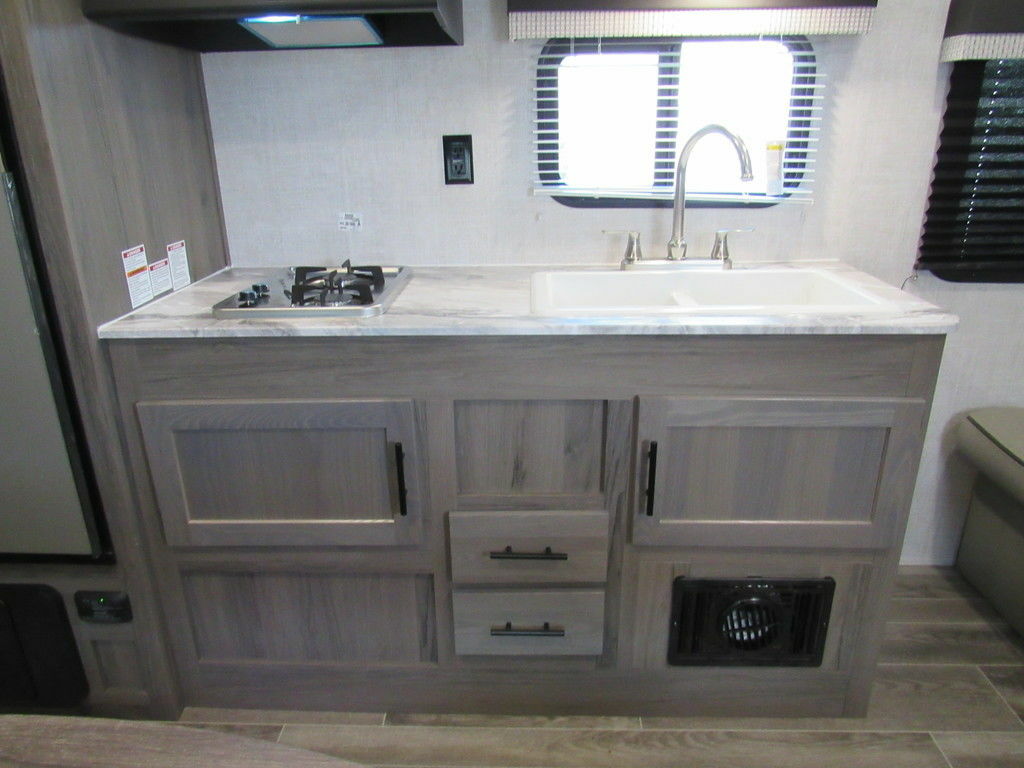 Kitchen with a gas burner, sink and cabinets.