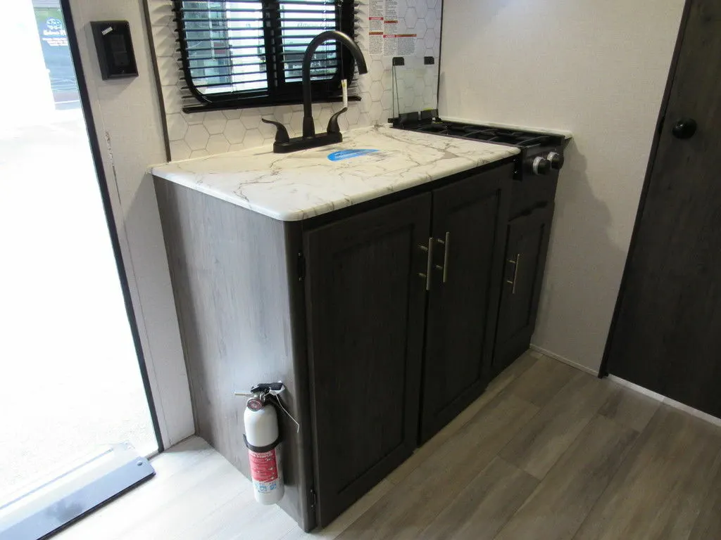 Kitchen with a gas burner, sink and cabinets.