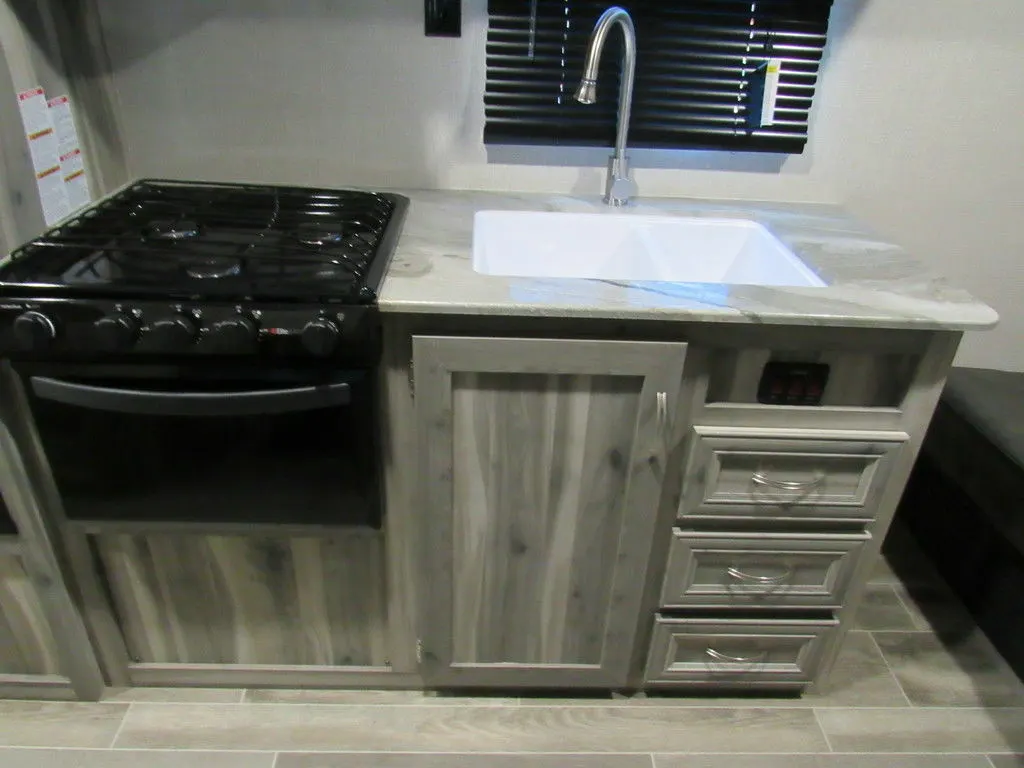 Kitchen with a gas burner, sink and cabinets.