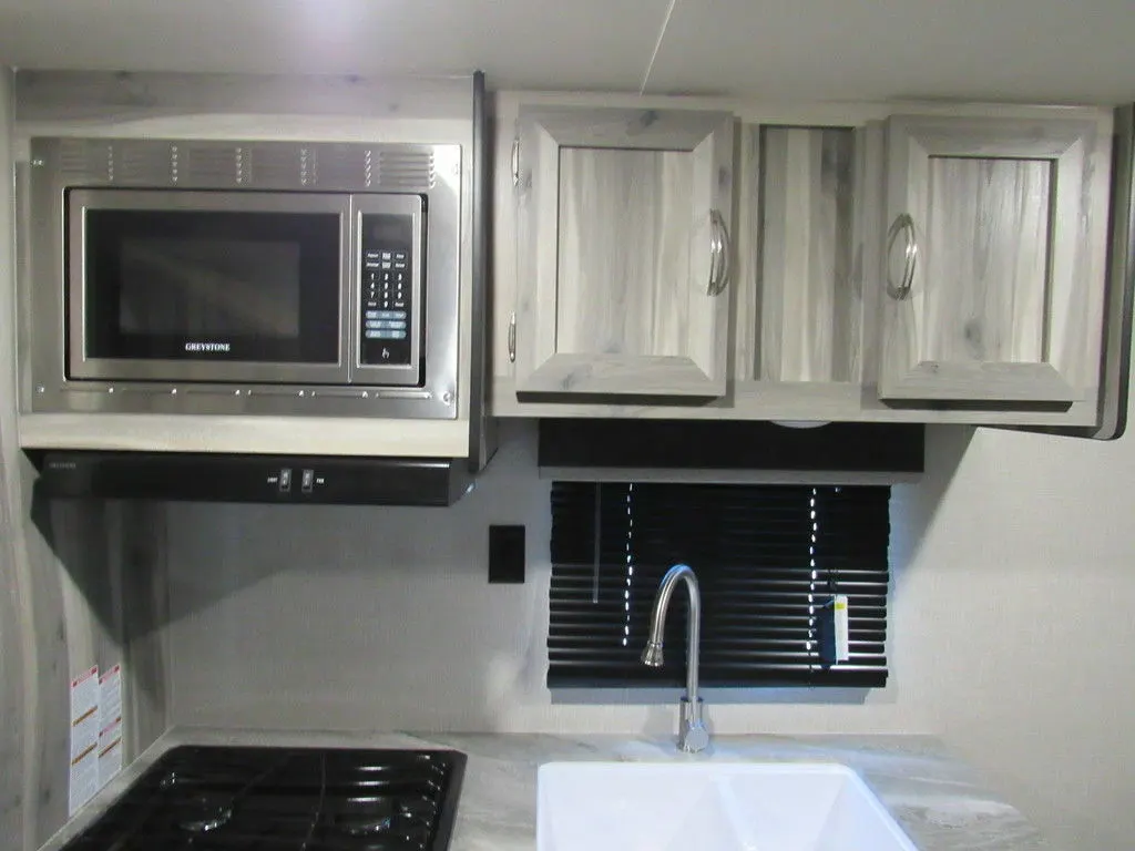 Kitchen with a gas burner, oven, sink and cabinets.