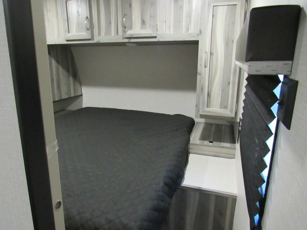 Bedroom with a queen size bed, overhead shelf and a shirt closet.