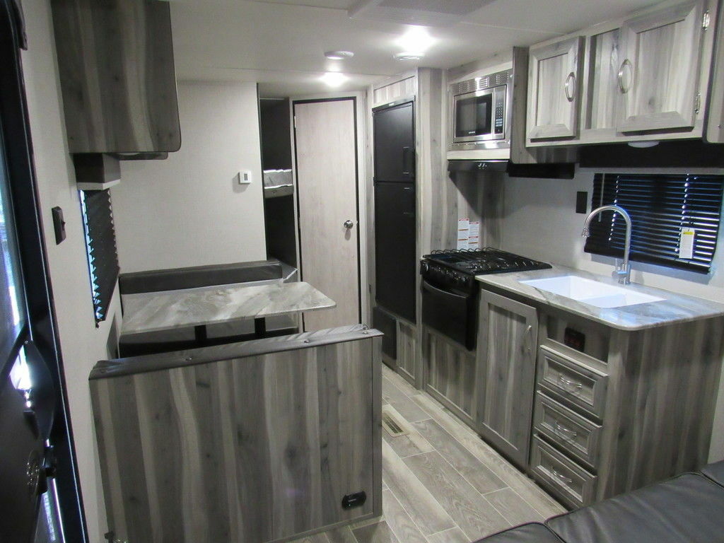 Interior view of the RV with a dinette, living space and a kitchen.