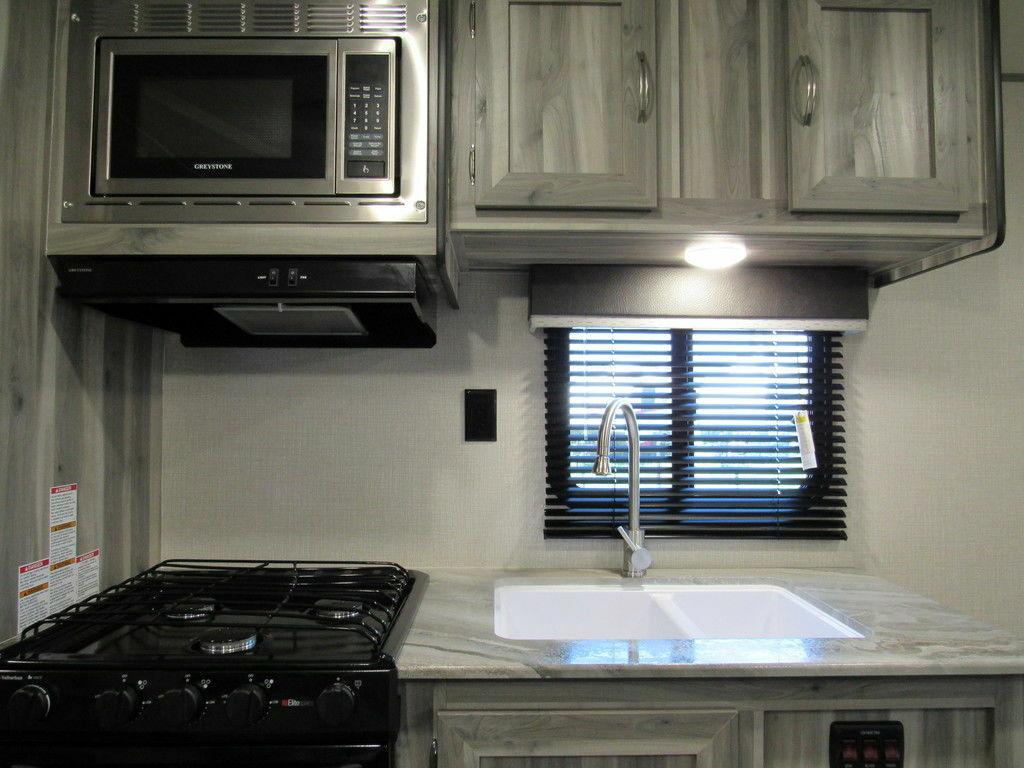 Kitchen with a gas burner, fridge, oven, sink and cabinets.