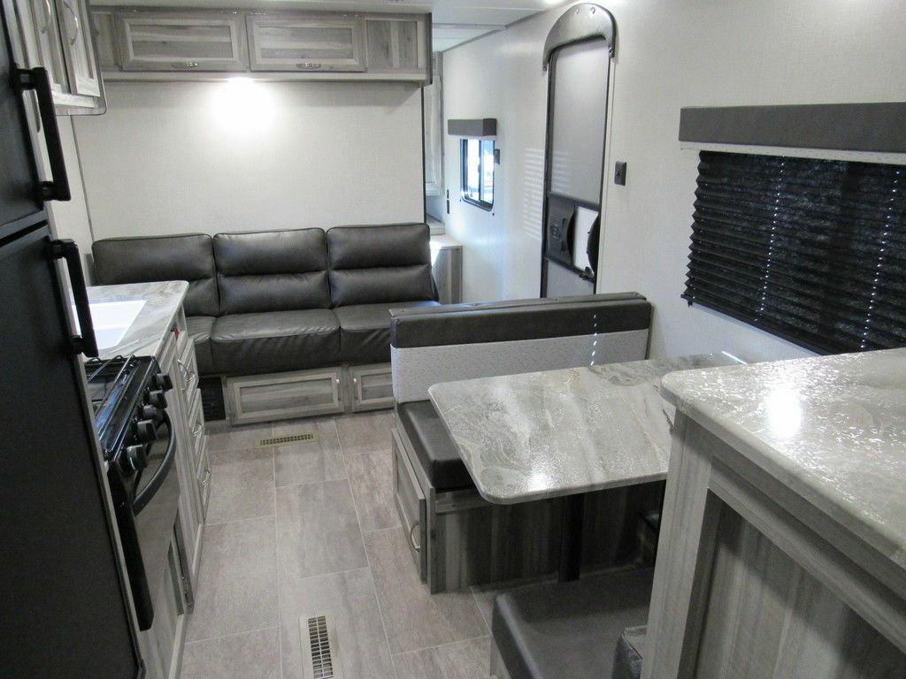 Interior view of the RV with a dinette, living space and a kitchen.