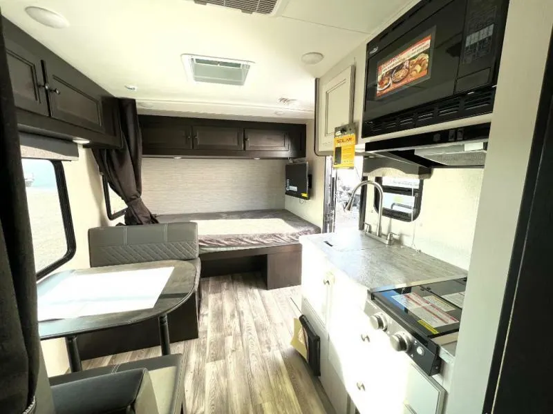 Interior view of the RV with a dinette, living space and a kitchen.