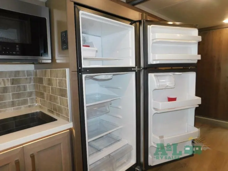 Kitchen with a gas burner, fridge, oven, and cabinets.