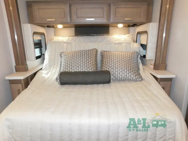 Bedroom with a queen size bed and overhead cabinets.