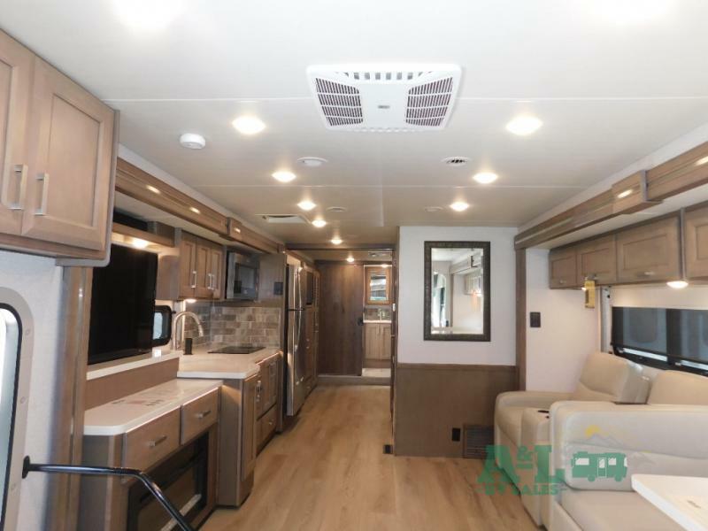 Interior view of the RV with a dinette, living space and a kitchen.