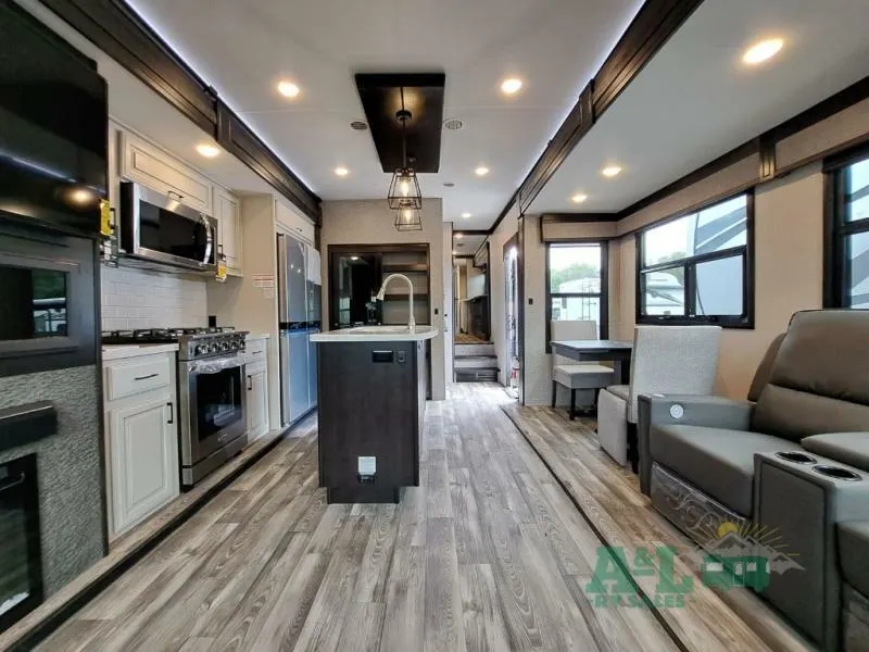 Interior view of the RV with a dinette, living space and a kitchen.